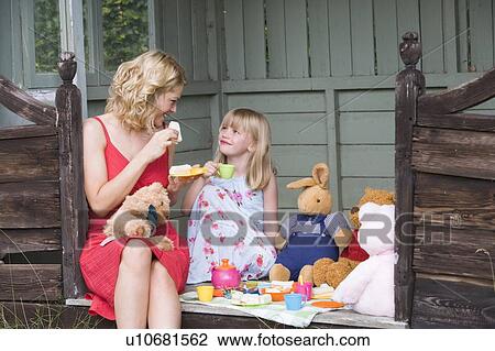 Woman and young girl in shed playing tea and smiling View Large Photo Image Stock Image - Woman and young girl in shed playing tea and smiling. Fotosearch