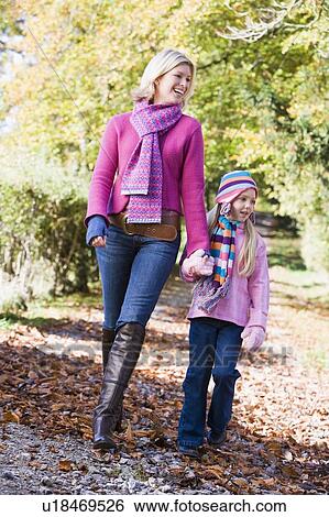 Woman and young girl walking outdoors in park and smiling View Large Photo Image Stock Photograph - Woman and young girl walking outdoors in park and smiling. Fotosearch