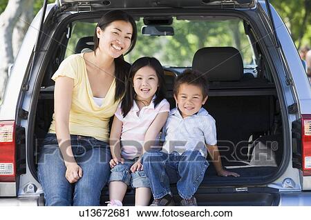 Woman with two children sitting in back of van smiling View Large Photo Image Stock Image - Woman with two children sitting in back of van smiling. Fotosearch