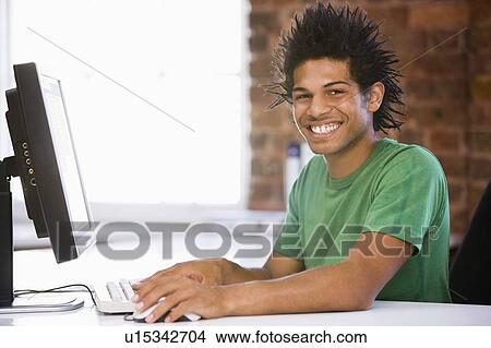 Businessman in office typing on computer smiling View Large Photo Image Picture - Businessman in office typing on computer smiling. Fotosearch