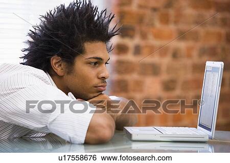 Businessman sitting in office with laptop View Large Photo Image Stock Photograph - Businessman sitting in office with laptop. Fotosearch