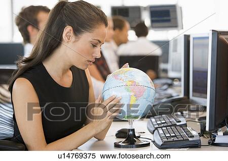 Stock Photography - Businesswoman in office space with desk globe. Fotosearch