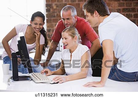 Five businesspeople in office space looking at computer smiling View Large Photo Image Stock Image - Five businesspeople in office space looking at computer smiling. Fotosearch