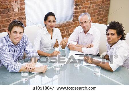 Four businesspeople in boardroom smiling View Large Photo Image Stock Photo - Four businesspeople in boardroom smiling. Fotosearch