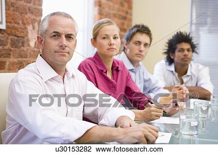 Stock Image - Four businesspeople in boardroom. Fotosearch