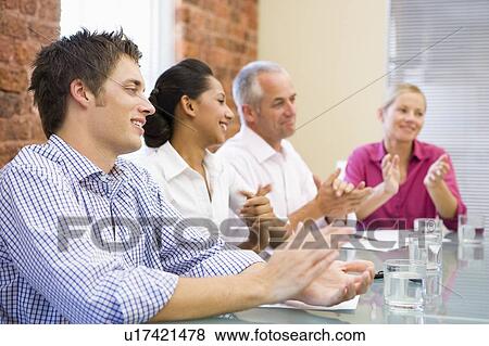 Four businesspeople in boardroom applauding and smiling View Large Photo Image Stock Photo - Four businesspeople in boardroom applauding and smiling. Fotosearch