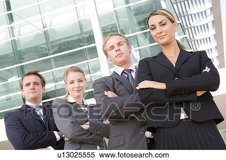 Stock Photography - Four businesspeople standing outdoors smiling. Fotosearch