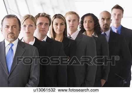 Group of co-workers standing in office space smiling (high key/depth of field) View Large Photo Image Stock Image - Group of co-workers standing in office space smiling (high key/depth of field). Fotosearch