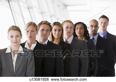 Group of co-workers standing in office space smiling (high key/depth of field) View Large Photo Image Stock Photo - Group of co-workers standing in office space smiling (high key/depth of field). Fotosearch