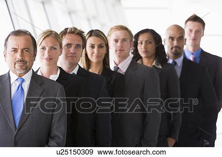 Stock Photo - Group of co-workers standing in office space smiling (high key/depth of field). Fotosearch