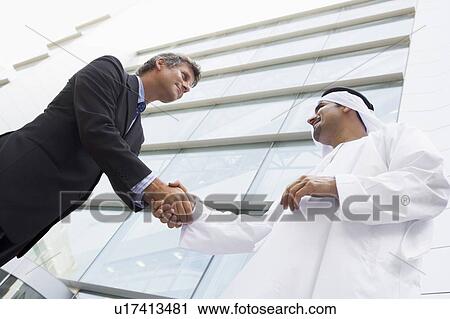 Two businessmen outdoors by building shaking hands and smiling (high key/selective focus) View Large Photo Image Stock Image - Two businessmen outdoors by building shaking hands and smiling (high key/selective focus). Fotosearch