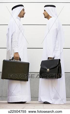 Two businessmen standing outdoors with briefcases View Large Photo Image Stock Photography - Two businessmen standing outdoors with briefcases. Fotosearch