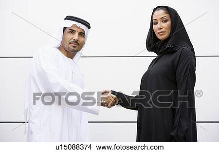 Two businesspeople standing outdoors shaking hands View Large Photo Image Picture - Two businesspeople standing outdoors shaking hands. Fotosearch