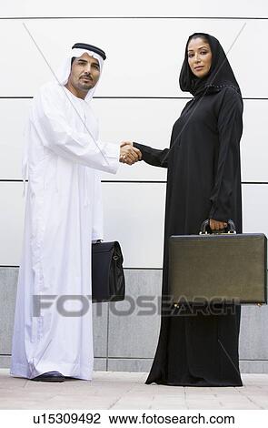 Two businesspeople standing outdoors with briefcases shaking hands View Large Photo Image Stock Image - Two businesspeople standing outdoors with briefcases shaking hands. Fotosearch