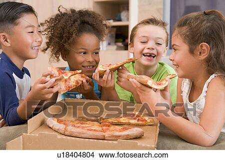Four young children indoors eating pizza smiling View Large Photo Image Picture - Four young children indoors eating pizza smiling. Fotosearch