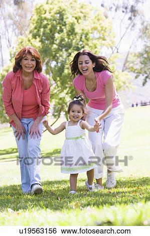 Stock Photograph - Grandmother with adult daughter and granddaughter in park. Fotosearch