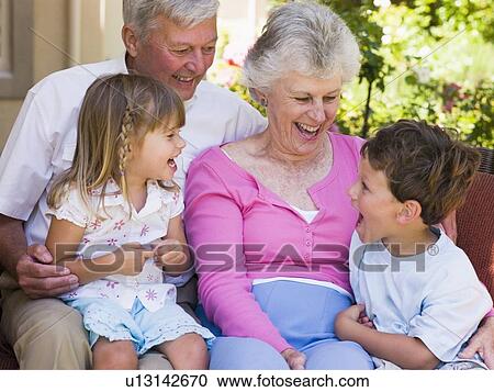 Stock Image - Grandparents laughing with grandchildren.. Fotosearch