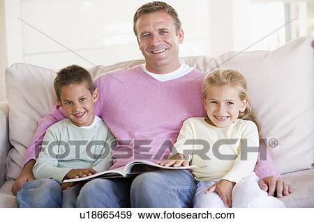 Man and two children sitting in living room reading book and smiling View Large Photo Image Stock Photo - Man and two children sitting in living room reading book and smiling. Fotosearch