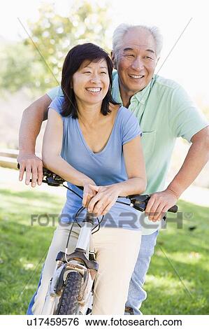 Mature couple bike riding. View Large Photo Image Stock Photograph - Mature couple bike riding.. Fotosearch