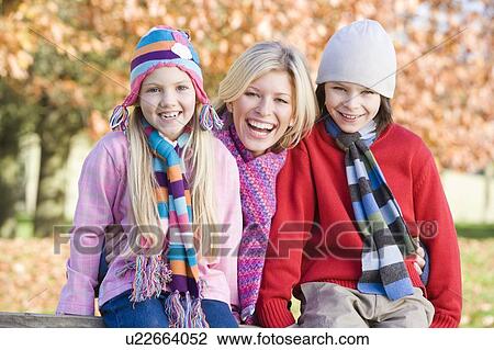 Mother and two young children outdoors in park smiling View Large Photo Image Stock Image - Mother and two young children outdoors in park smiling. Fotosearch