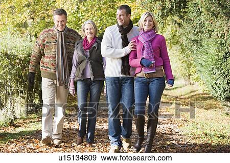 Two couples walking outdoors in park smiling View Large Photo Image Stock Photo - Two couples walking outdoors in park smiling. Fotosearch