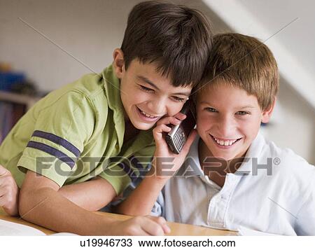 Two Young Boys Calling Someone On A Cellphone View Large Photo Image Stock Image - Two Young Boys Calling Someone On A Cellphone. Fotosearch