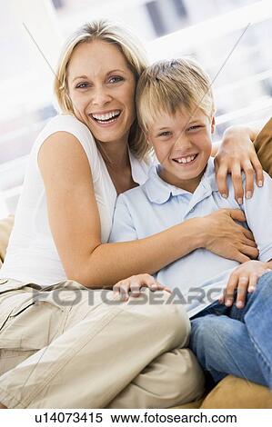 Woman and young boy sitting in living room smiling View Large Photo Image Stock Photography - Woman and young boy sitting in living room smiling. Fotosearch