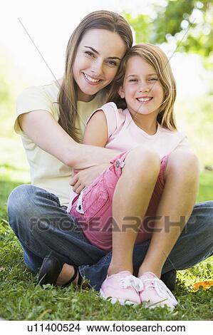 Woman and young girl outdoors embracing and smiling View Large Photo Image Picture - Woman and young girl outdoors embracing and smiling. Fotosearch