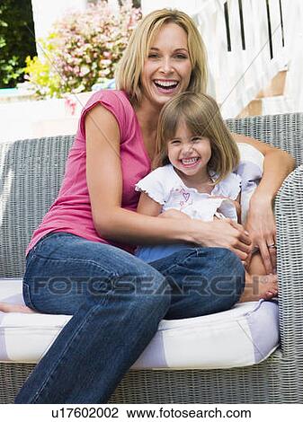 Woman and young girl sitting on patio laughing View Large Photo Image Stock Image - Woman and young girl sitting on patio laughing. Fotosearch