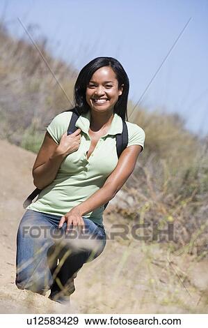 Woman crouching on beach path smiling View Large Photo Image Stock Photo - Woman crouching on beach path smiling. Fotosearch
