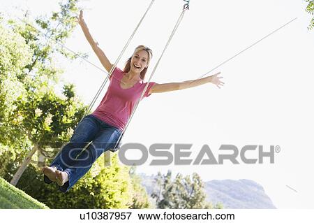 Woman on tree swing smiling View Large Photo Image Stock Photo - Woman on tree swing smiling. Fotosearch