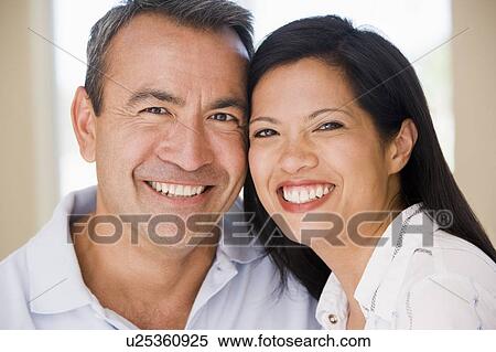 Stock Photography - Couple in living room smiling. Fotosearch
