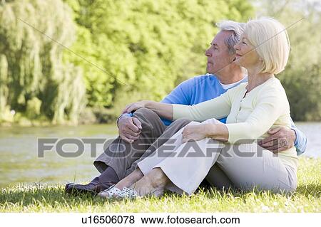 Stock Photo - Couple outdoors at park by lake. Fotosearch