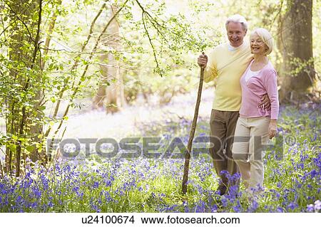 Couple walking outdoors with walking stick smiling View Large Photo Image Picture - Couple walking outdoors with walking stick smiling. Fotosearch