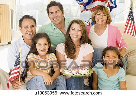 Family in living room on fourth of July with flags and cookies smiling View Large Photo Image Stock Photograph - Family in living room on fourth of July with flags and cookies smiling. Fotosearch