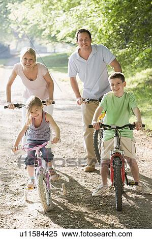 Family on bikes on path smiling View Large Photo Image Stock Photography - Family on bikes on path smiling. Fotosearch