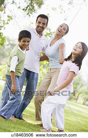 Family outdoors in park bonding and smiling (selective focus) View Large Photo Image Stock Photograph - Family outdoors in park bonding and smiling (selective focus). Fotosearch