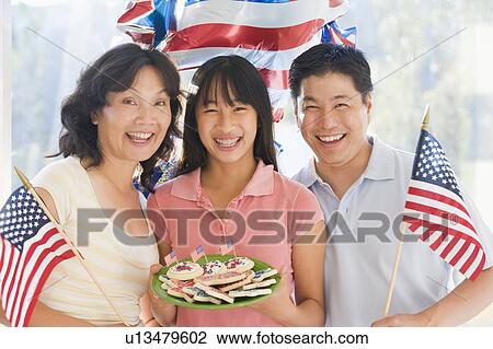 Family outdoors on fourth of July with flags and cookies smiling View Large Photo Image Stock Image - Family outdoors on fourth of July with flags and cookies smiling. Fotosearch