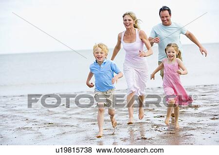 Stock Photo - Family running on beach smiling. Fotosearch