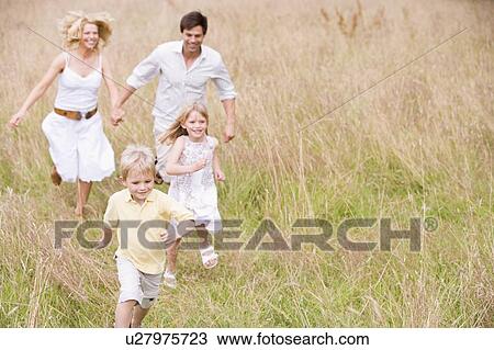 Stock Image - Family running outdoors smiling. Fotosearch