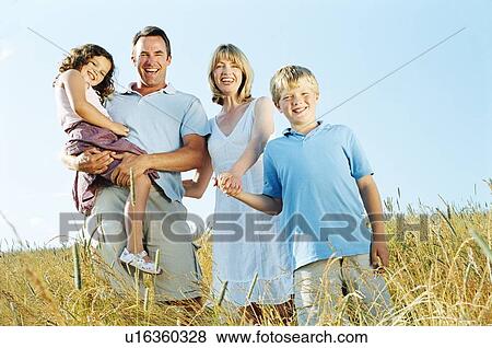 Family standing outdoors holding hands smiling View Large Photo Image Stock Photo - Family standing outdoors holding hands smiling. Fotosearch