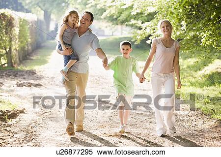 Stock Photography - Family walking outdoors holding hands and smiling. Fotosearch
