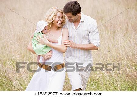 Stock Photo - Family walking outdoors smiling. Fotosearch