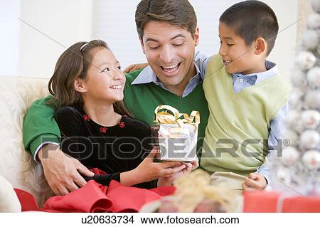 Picture - Father Being Given A Christmas Present By His Daughter And Son. Fotosearch