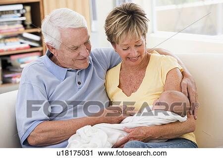 Grandparents in living room with baby smiling View Large Photo Image Stock Image - Grandparents in living room with baby smiling. Fotosearch