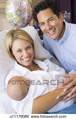 New mother with baby and husband in hospital smiling View Large Photo Image Stock Photo - New mother with baby and husband in hospital smiling. Fotosearch