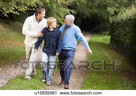 Two men and young boy walking on path outdoors smiling (selective focus) View Large Photo Image Stock Image - Two men and young boy walking on path outdoors smiling (selective focus). Fotosearch