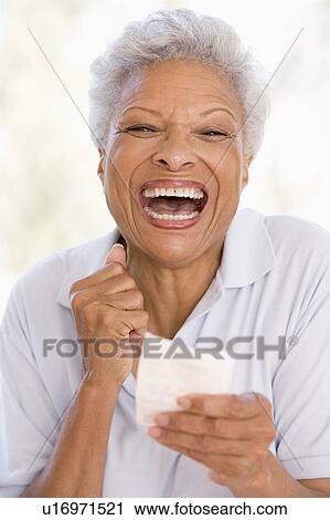 Woman with winning lottery ticket excited and smiling View Large Photo Image Stock Image - Woman with winning lottery ticket excited and smiling. Fotosearch