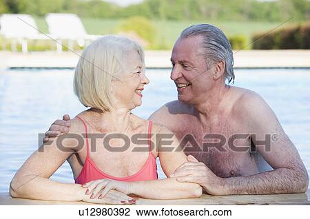 Stock Image - Couple in outdoor pool smiling. Fotosearch