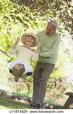 Couple outdoors with tree swing smiling View Large Photo Image Picture - Couple outdoors with tree swing smiling. Fotosearch